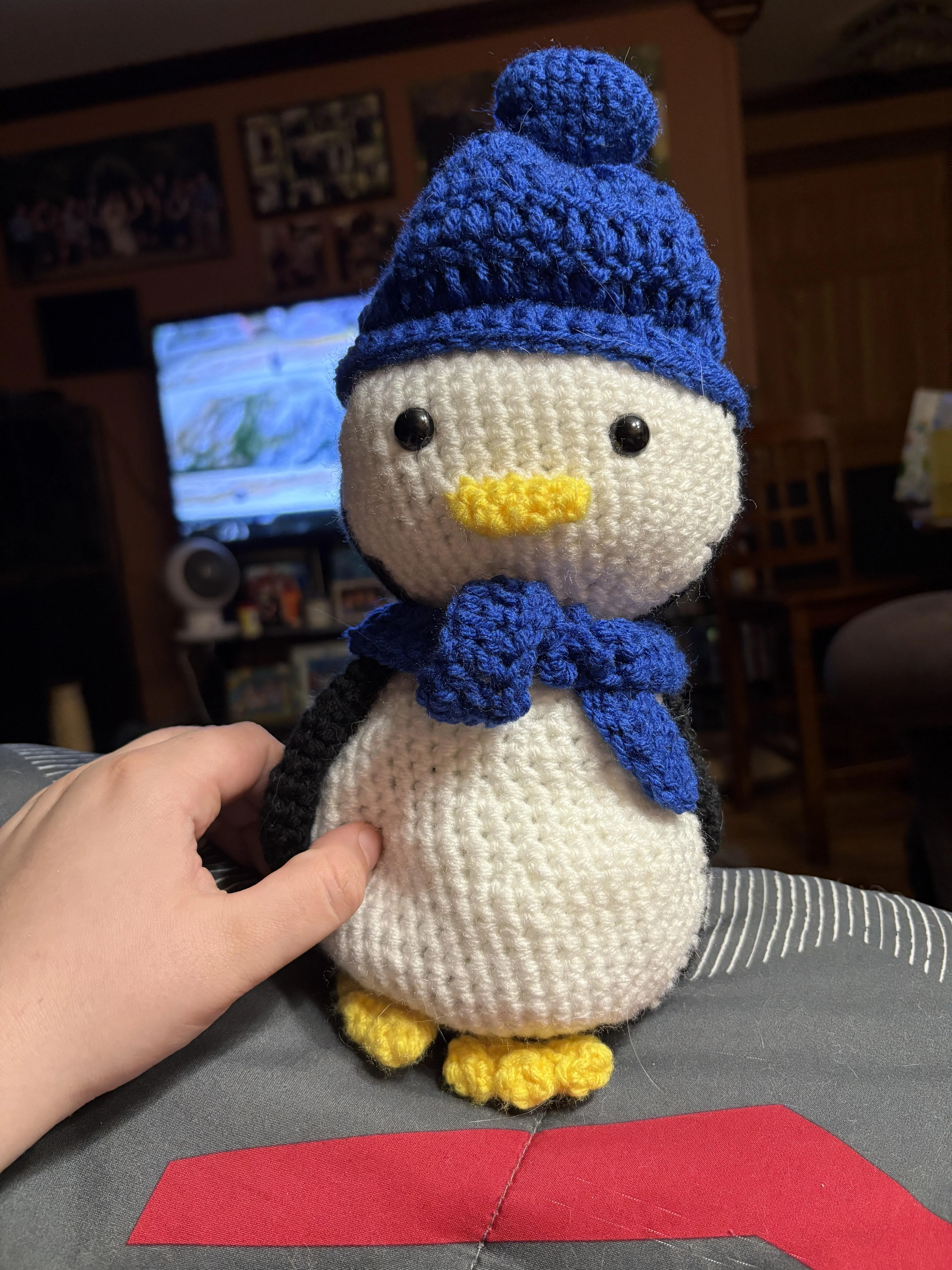 Crochet penguin with a blue hat and scarf